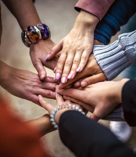 A close-up of a warm professional hand stack in a bright medical clinic, symbolizing career collaboration and joining the Lake Eye Associates team.
